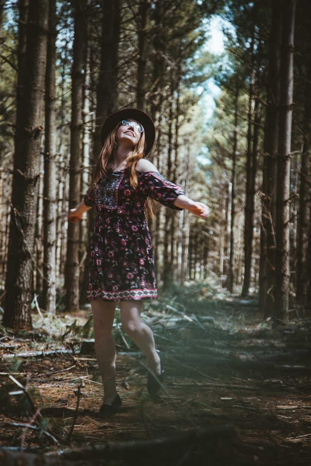 Woman standing confidently on a forest path, representing self-trust, confidence, and inner guidance.