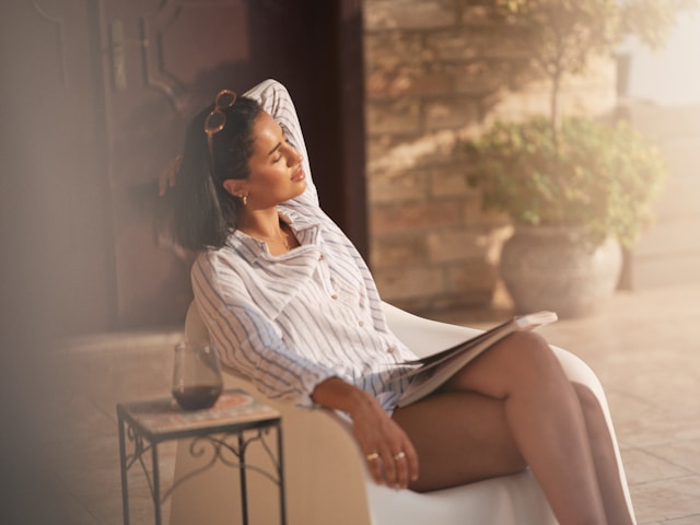 Woman sitting peacefully outside taking a purposeful pause to rest and reset.